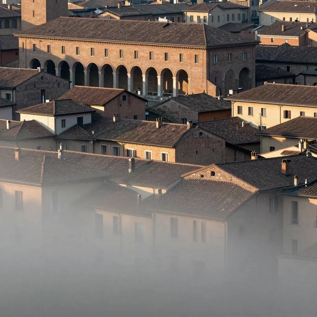 Bologna vista da lontano con portici e tetti in terracotta, luce radente e foschia morbida.